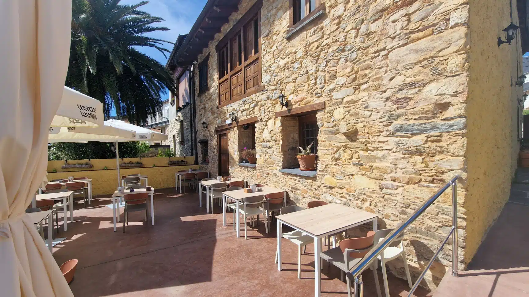 Terraza con mesas, sillas y sombrillas